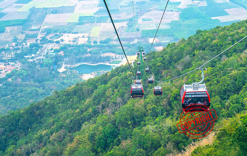 Aerial view of the lush forest and rocks from the Ba Den Mountain cable car cabin.